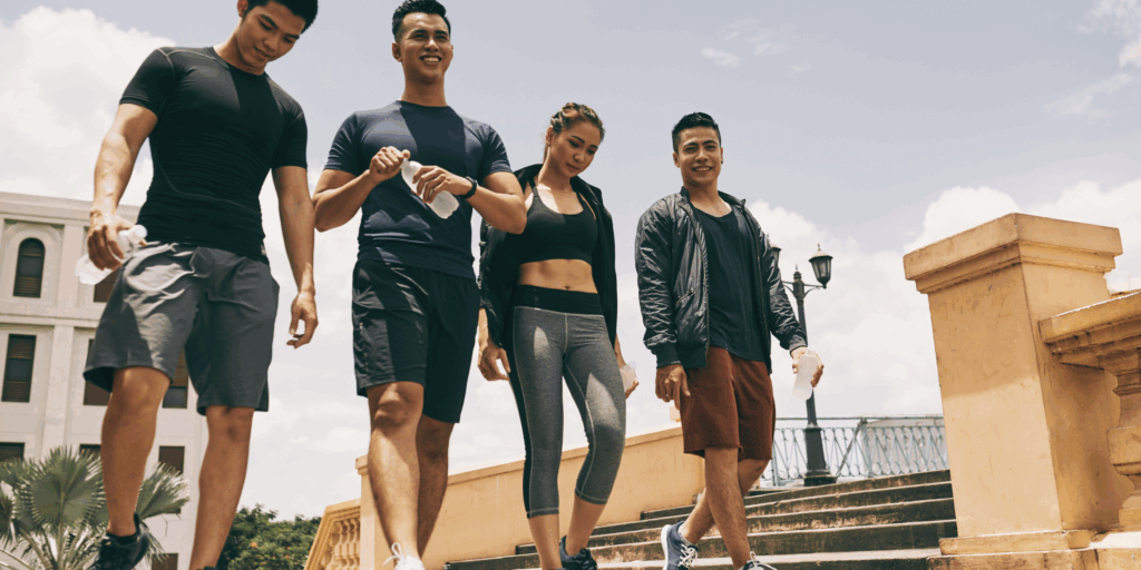 Four people in activewear (two men, two women) holding water bottles and yoga mats, representing real lifestyle trends in the activewear market in 2025.