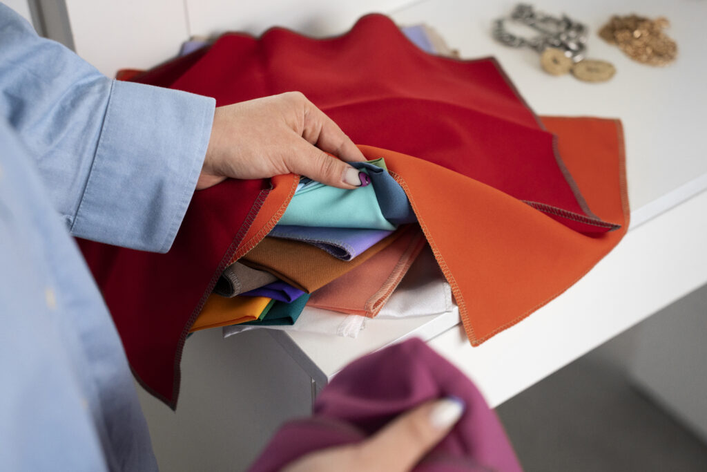 Person choosing fabrics by hand, comparing thickness and durability.
