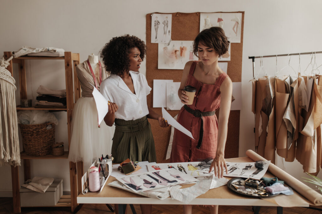 Two fashion designers discussing a garment sample, highlighting common mistakes in garment sampling that can cause delays and rework.